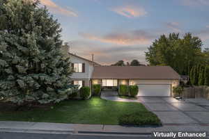 View of front of house with a yard and a garage