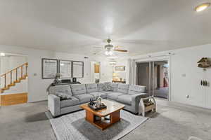 Carpeted living room with ceiling fan