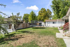 View of yard featuring a storage shed and a trampoline