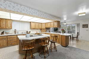 Kitchen with a breakfast bar, sink, a center island, and light carpet