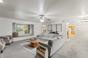 Carpeted living room with ceiling fan