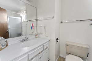 Bathroom featuring vanity, toilet, and walk in shower