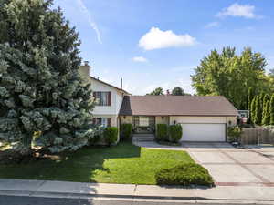 View of front of house with a front yard and a garage