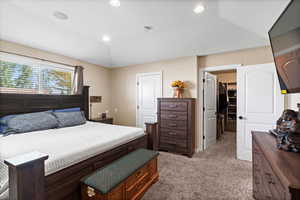 Carpeted bedroom with lofted ceiling, a walk in closet, and a closet