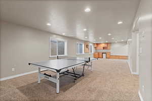 Rec room with light colored carpet and a textured ceiling