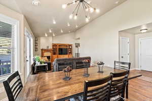 Dining space with lofted ceiling, a chandelier, and light hardwood / wood-style floors