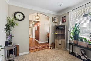 Interior space featuring crown molding, wood-type flooring, and a chandelier