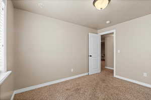 Carpeted empty room with a textured ceiling