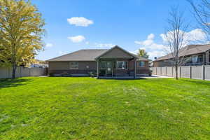 Rear view of house featuring a patio area and a lawn