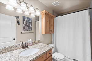 Bathroom with walk in shower, toilet, and vanity