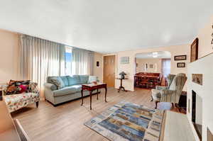 Living room featuring light wood-type flooring and a tile fireplace