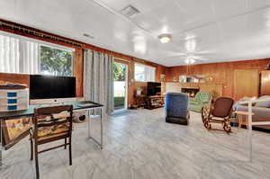 Living room featuring ceiling fan and wooden walls