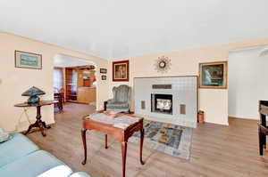 Living room with hardwood / wood-style floors and a tile fireplace