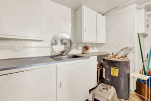 Laundry area featuring hardwood / wood-style floors and water heater