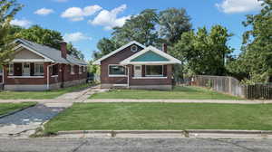 View of front of home featuring covered porch and a front lawn