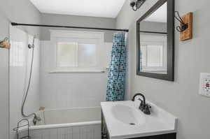 Bathroom with vanity and shower / bath combination with curtain