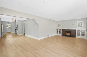 Unfurnished living room with a fireplace and light hardwood / wood-style flooring