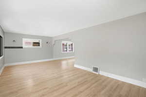 Unfurnished living room with a wealth of natural light and light hardwood / wood-style flooring