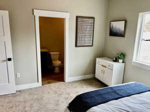 Bedroom featuring carpet floors, baseboards, and connected bathroom
