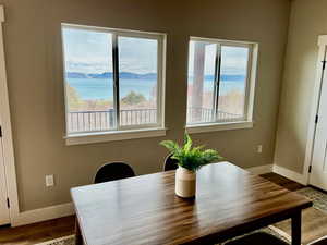 Dining space with dark wood-style flooring, baseboards, and a water view
