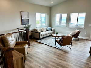 Living area with baseboards, recessed lighting, wood finished floors, and vaulted ceiling