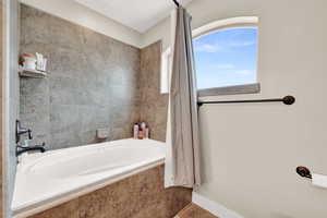 Bathroom featuring tile patterned flooring and tiled tub