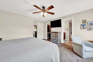 Carpeted bedroom with connected bathroom, a walk in closet, ceiling fan, and a closet