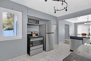 Kitchen featuring stainless steel appliances and dark stone counters