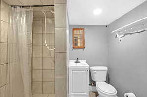 Bathroom featuring vanity, toilet, curtained shower, and tile patterned floors