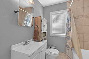 Full bathroom featuring vanity, toilet, and shower / tub combo