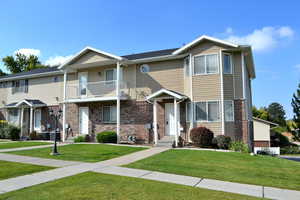 Townhome / multi-family property featuring a balcony and a front yard