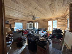 Interior space with ceiling fan, wood ceiling, and log walls