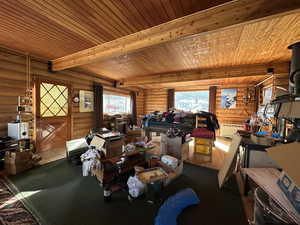 Dining area featuring hardwood / wood-style flooring, beam ceiling, wood ceiling, and log walls