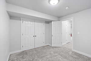 Unfurnished bedroom featuring a closet and light carpet