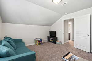 Living room with carpet and vaulted ceiling