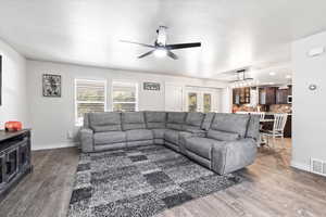 Living room with plenty of natural light, ceiling fan, french doors, and hardwood / wood-style flooring