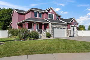 Craftsman-style home with a garage, covered porch, and a front yard