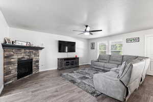 Living room featuring ceiling fan, hardwood / wood-style flooring, and a fireplace