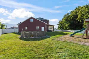 View of yard with a fenced in pool and a playground