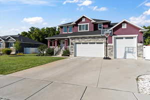 Craftsman inspired home featuring a garage and a front lawn