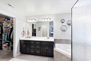 Bathroom featuring tile patterned flooring, independent shower and bath, and vanity