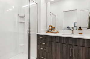 Bathroom featuring walk in shower and vanity