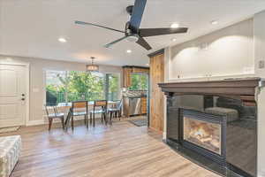 Living room with ceiling fan and light hardwood / wood-style floors