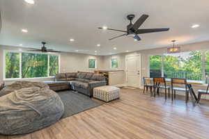 Living room with plenty of natural light, ceiling fan, and light hardwood / wood-style flooring