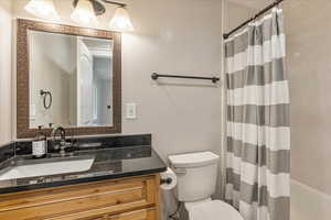 Master Bath #1 Full bathroom with shower / bathtub combination with curtain, toilet, and vanity