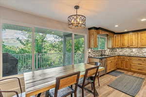 Kitchen with light wood-type flooring, a wealth of natural light, and an inviting chandelier