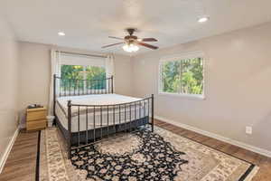 Master Bedroom with Master Bath attached ceiling fan and wood-type flooring