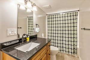 Bathroom #3 Downstairs with a textured ceiling, vanity, toilet, and a shower with shower curtain