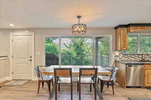 Dining space with light wood-type flooring, a chandelier, and sink