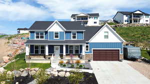 View of front of home featuring a front lawn, a garage, and a porch